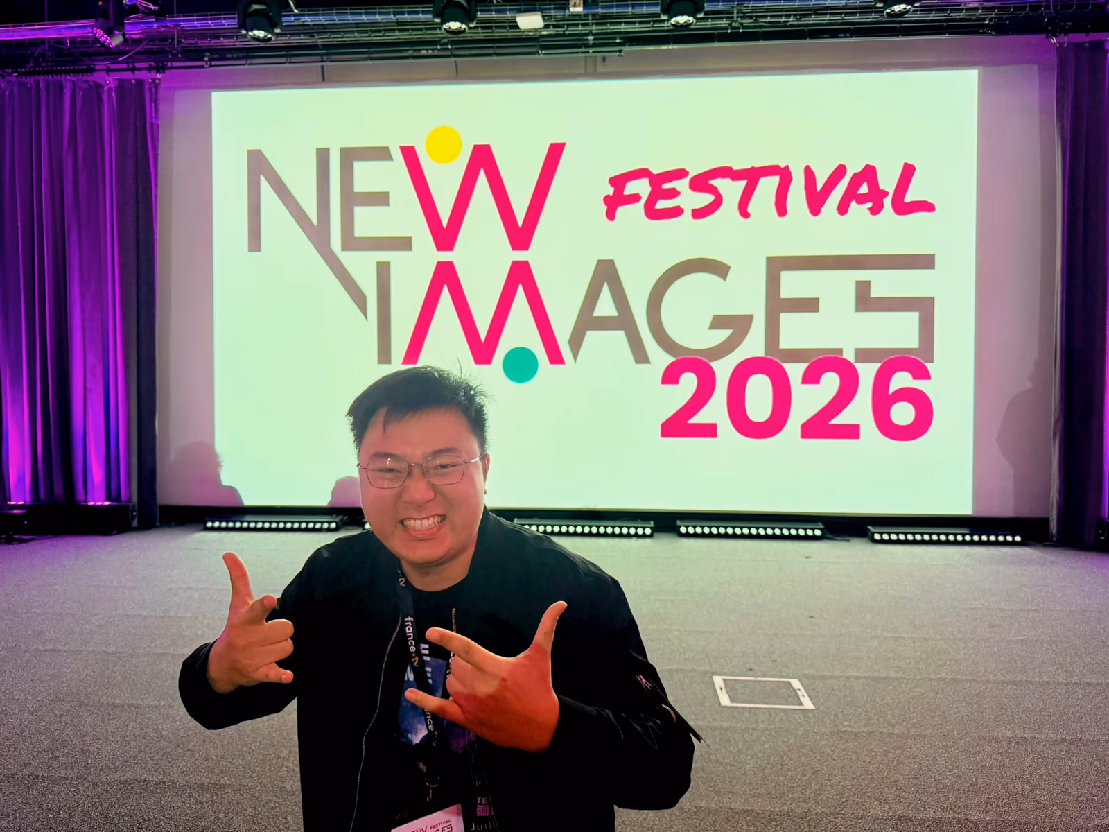 程威誌站在 NewImages Festival 2026 主視覺前